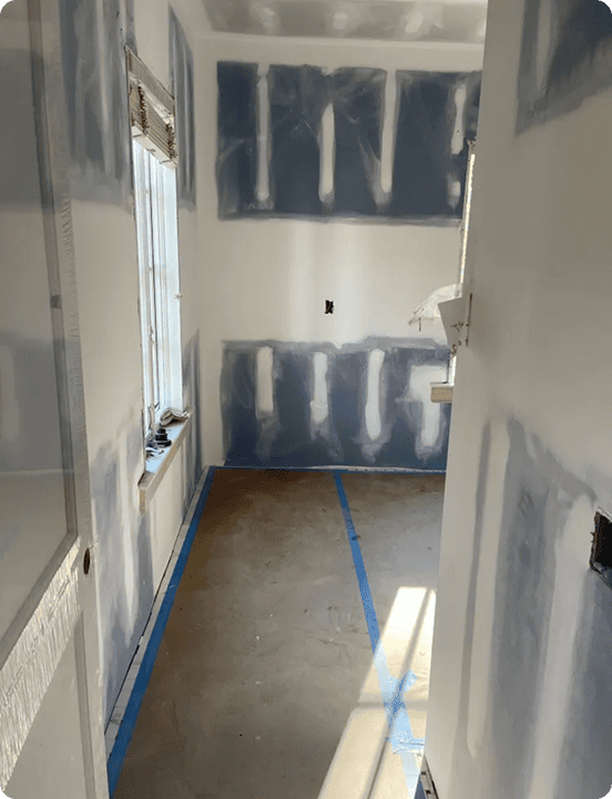 Hallway of a room being prepped with mudded drywall seams and painter's tape | Blue Rock Roofing & Construction | Best drywall in Fort Mill, SC