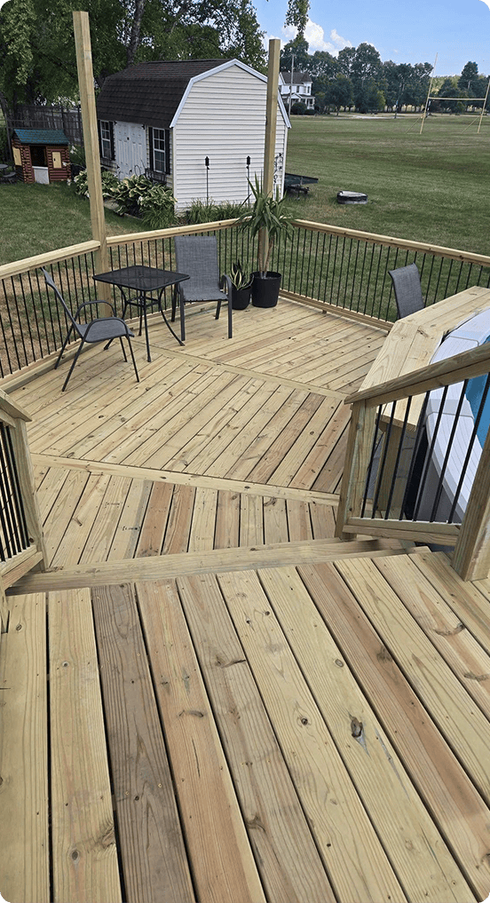 New light-toned wood deck with black metal balusters and patio furniture | Blue Rock Roofing & Construction | Best deck building in Fort Mill, SC